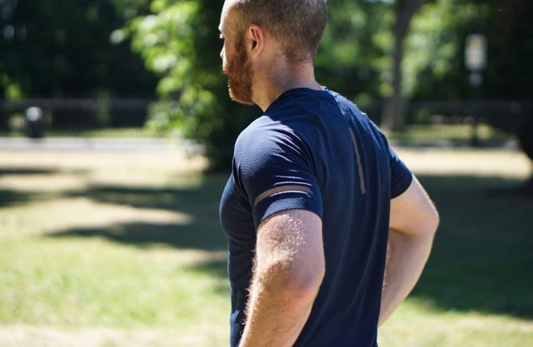selective focus photography of man standing near trees